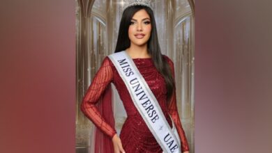 Mariam Mohamed wearing a crown and a red gown with a sash reading “Miss Universe UAE.”