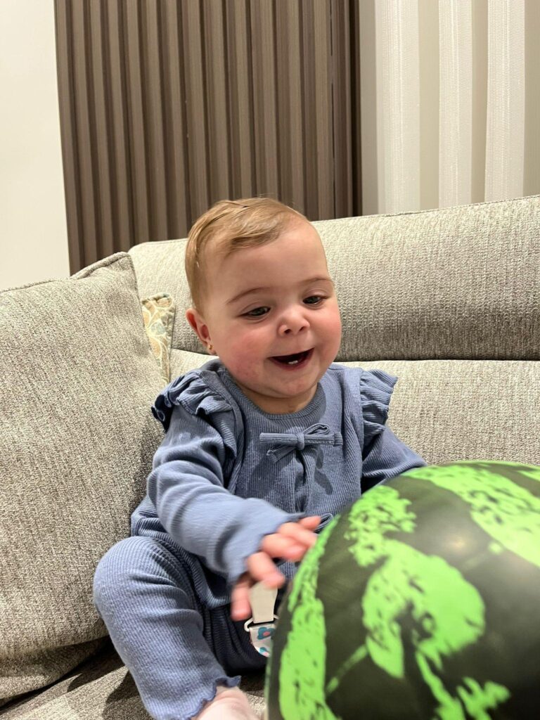 Palestinian infant Mira Suhaib Akkad playing happily after recovering from heart surgery.