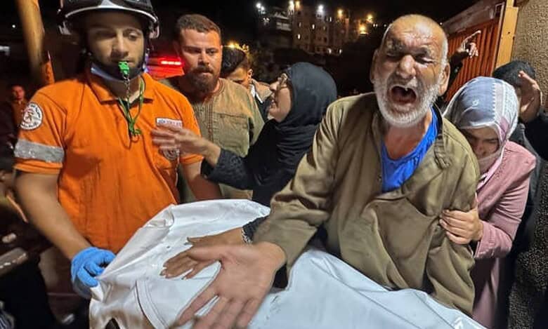 A grieving Palestinian man reacts beside a covered body after an Israeli strike on Tuesday night, October 28.