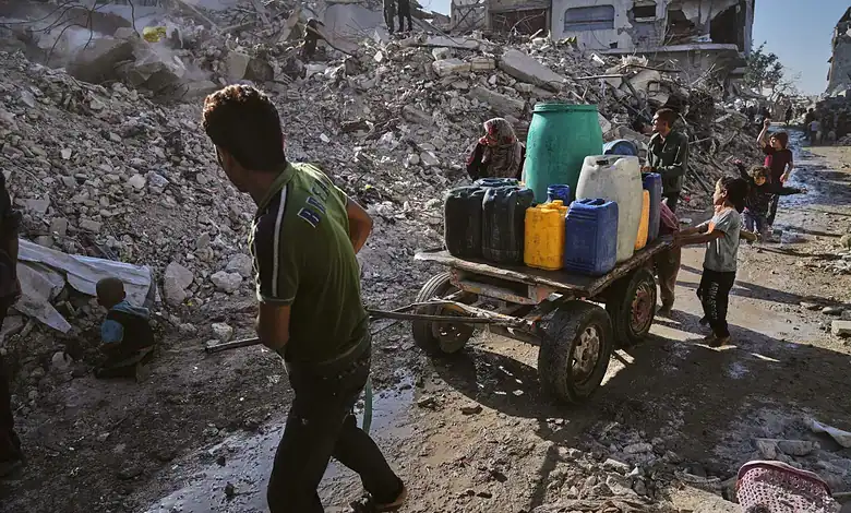 Palestinians collect and transport water through the rubble-strewn streets of Gaza City following heavy destruction.