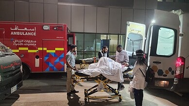 Indian embassy officials and medical staff assist a paralysed Hyderabad man being transferred on a stretcher between ambulances at Riyadh airport, Saudi Arabia.