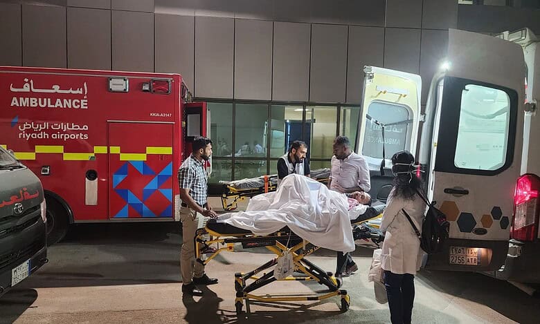 Indian embassy officials and medical staff assist a paralysed Hyderabad man being transferred on a stretcher between ambulances at Riyadh airport, Saudi Arabia.