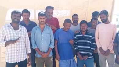 A group of stranded Telangana migrant workers in Jordan standing together under the sun, appealing for help to return home.
