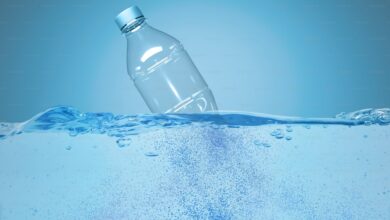 Plastic bottle half-submerged in water with bubbles rising, symbolising water pollution.