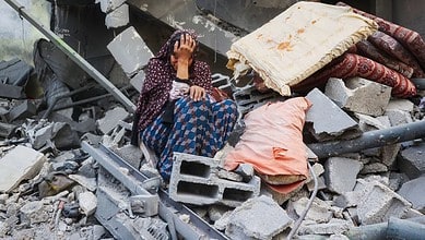 A Palestinian woman weeps outside her destroyed home after an Israeli air strike in central Gaza.