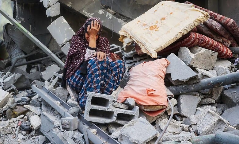 A Palestinian woman weeps outside her destroyed home after an Israeli air strike in central Gaza.