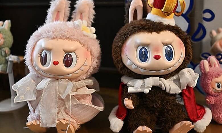 Two Labubu collectible dolls dressed in furry costumes with bunny ears displayed on a table.