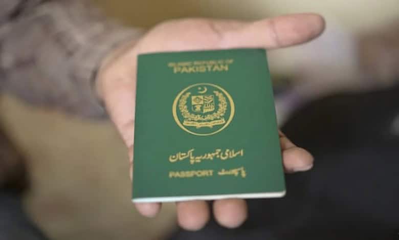 A person holding a Pakistani passport in their hand.