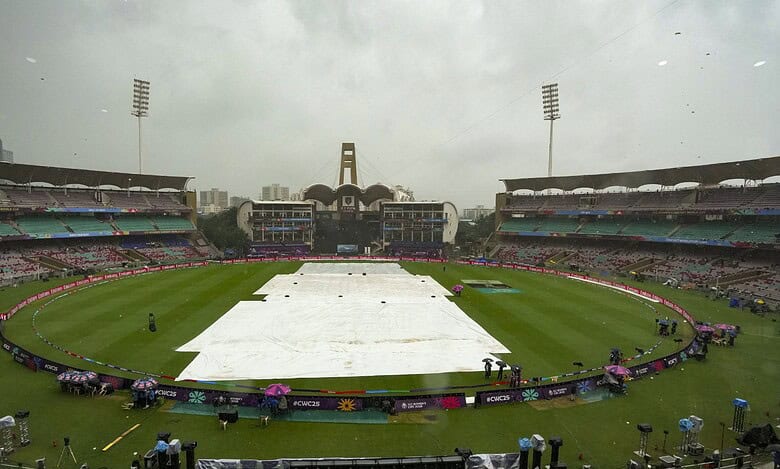 Groundsmen cover the field amid rain at the DY Patil Stadium ahead of the ICC Women's World Cup 2025 cricket final match between India Women and South Africa Women, in Navi Mumbai, Sunday, Nov. 2, 2025. (PTI Photo/Kunal Patil)