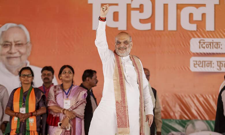 Union Home Minister Amit Shah waves to the gathering during a rally ahead of the Bihar Assembly elections in Sitamarhi.