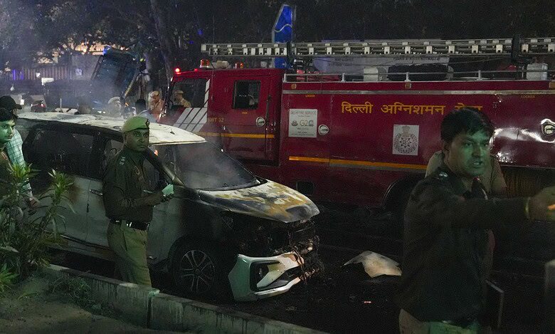 Police personnel at the spot after a blast occurred in a parked car near Red Fort, leaving multiple vehicles in flames in New Delhi on Monday. Eight people have died and atleast 24 injured. (PTI Photo/Salman Ali)