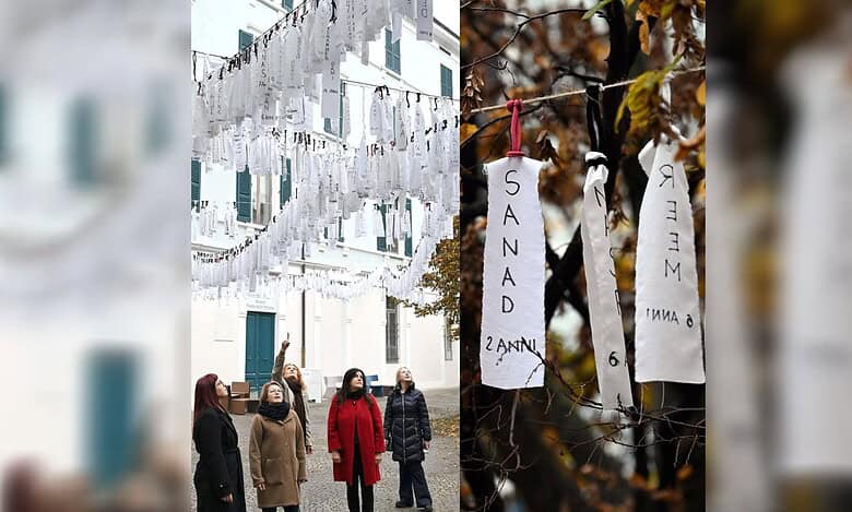 Left: Rows of white fabric strips bearing the handwritten names and ages of Palestinian children hang across a courtyard in Brescia, Italy, as several women look up at the installation. Right: Close-up of two white cloth ribbons tied to a branch, showing children’s names “SANAD” and “MEER” with their ages written below.