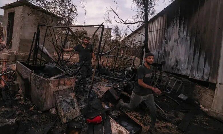 Palestinian men walk through the charred remains of a burned house after a settler attack in Beit Lid village, West Bank.