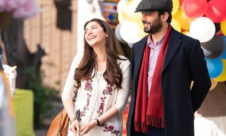 Mahira Khan and Fawad Khan share a warm moment outdoors, smiling during a scene from the film Neelofar, with colourful balloons in the background.