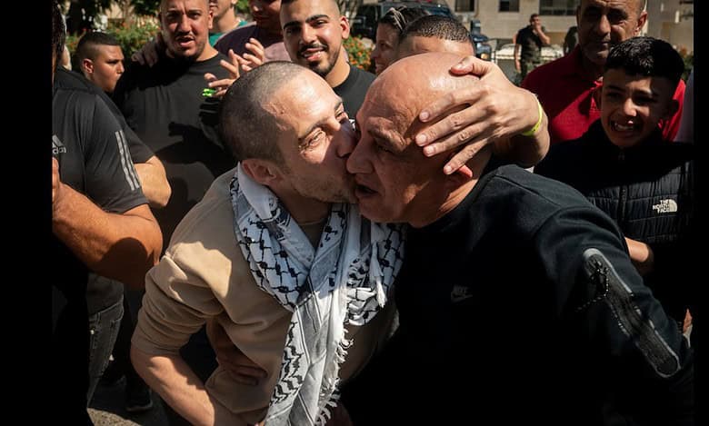 A released Palestinian prisoner kisses a relative as families gather in a subdued celebration in the West Bank.