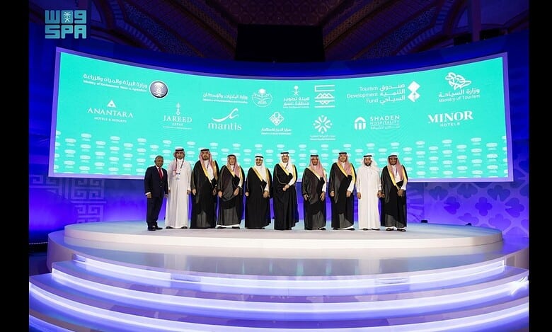 Officials and delegates stand on stage during the TOURISE 2025 Summit in Riyadh, where the Tourism Development Fund announced new projects.