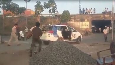 Image shows few people around a police vehicle in Adilabad