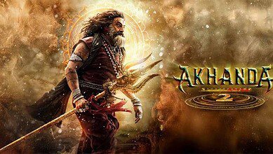 Movie poster for 'Akhanda 2' featuring a warrior with long hair and beard in traditional attire, holding a trident against a dramatic golden and dusty background with mystical circular symbols