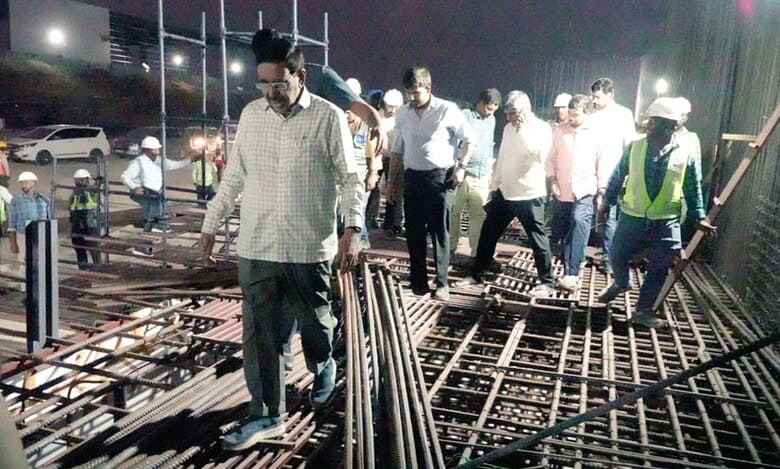 Construction site inspection with engineers and workers at night focusing on steel reinforcement.
