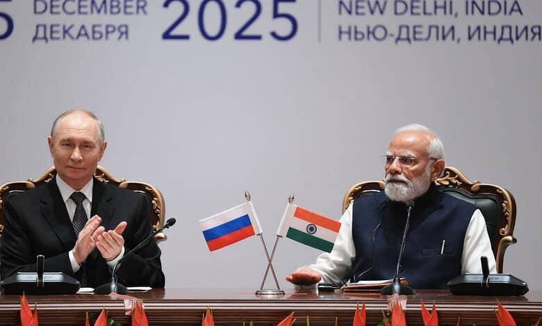 Russian President Vladimir Putin and Indian Prime Minister Narendra Modi seated at a formal diplomatic meeting with Russian and Indian flags, dated December 5, 2025, in New Delhi, India.