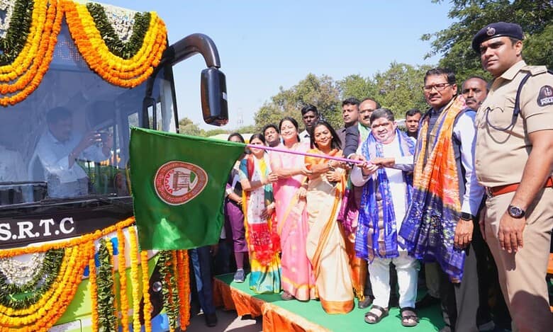 Officials and dignitaries inaugurate a decorated TGSRTC bus adorned with marigold flower garlands during a ceremonial event.