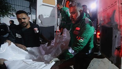 Palestinians carry the body of a person killed in an Israeli military strike as they arrive at Shifa Hospital in Gaza City.