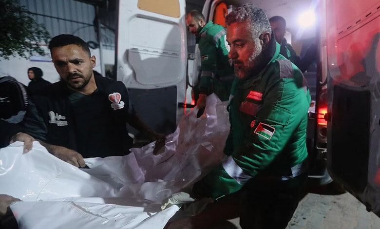 Palestinians carry the body of a person killed in an Israeli military strike as they arrive at Shifa Hospital in Gaza City.