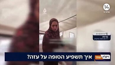 A woman struggles to keep herself warm inside a tent in Gaza