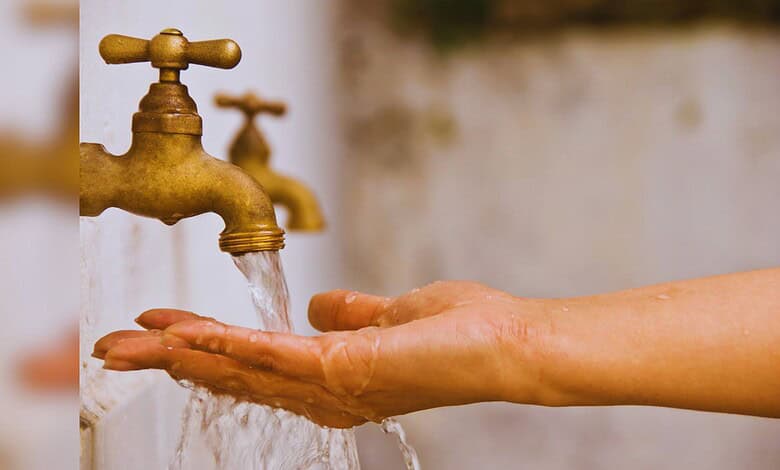 Hand washing under running water from a brass faucet