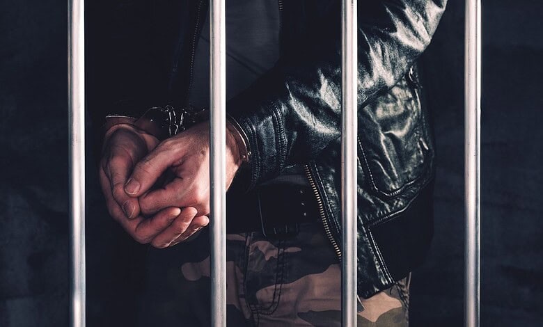 Handcuffed man behind prison bars (Representative Image)