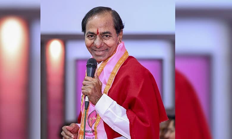 A man in traditional attire holding a microphone at an event.