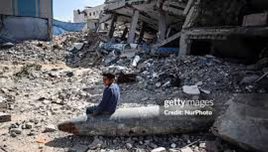 A boy sits amid rubble in Gaza