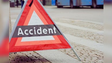 Image shows Traffic warning triangle on street indicating accident scene