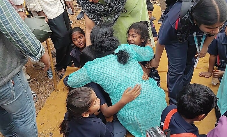 Image shows a woman hugging children after a bus accident