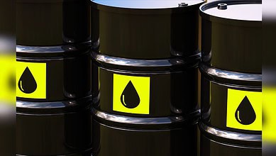 Image shows Black oil barrels with yellow labels featuring a droplet icon arranged in a group.
