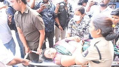 The image shows an ASHA worker who fell unconscious during a protest in Koti, being shifted to a hospital on February 23, 2026.