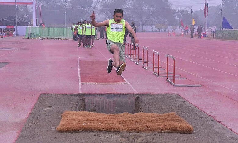 Young athlete jumping over hurdles during Indian Army Agniveer recruitment event.