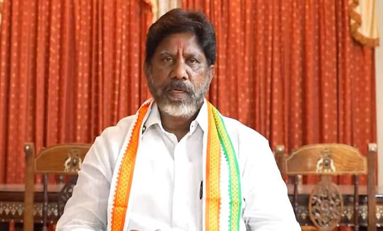 Indian politician speaking at a public event with traditional decorations.