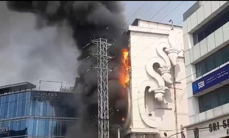 Fire at Hyderabad shopping mall with thick black smoke and flames engulfing the building.