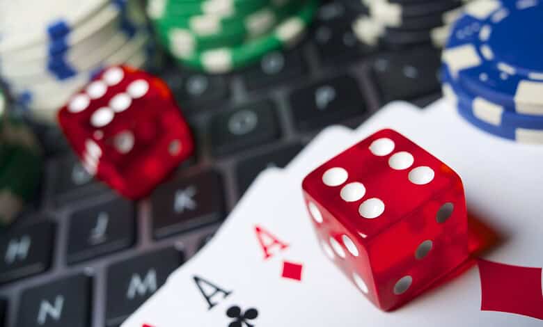 Online gaming fraud and gambling chips on a laptop keyboard in Hyderabad.