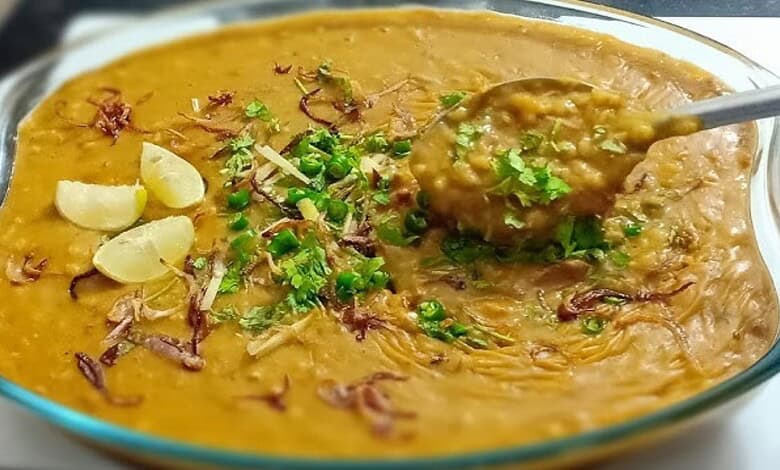 Traditional Hyderabadi Haleem served in a glass dish with garnishes, highlighting regional culinary diver.