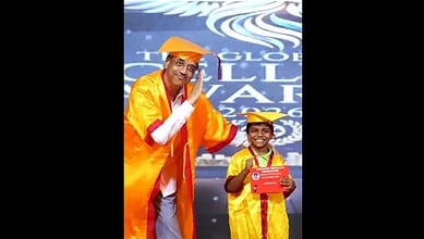 Principal in Pushpa pose at convocation, dressed in academic gown, celebrating achievement.