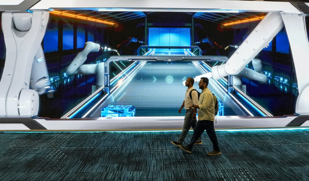 Robots and visitors at the world's largest AI summit in Delhi showcase advanced technology.