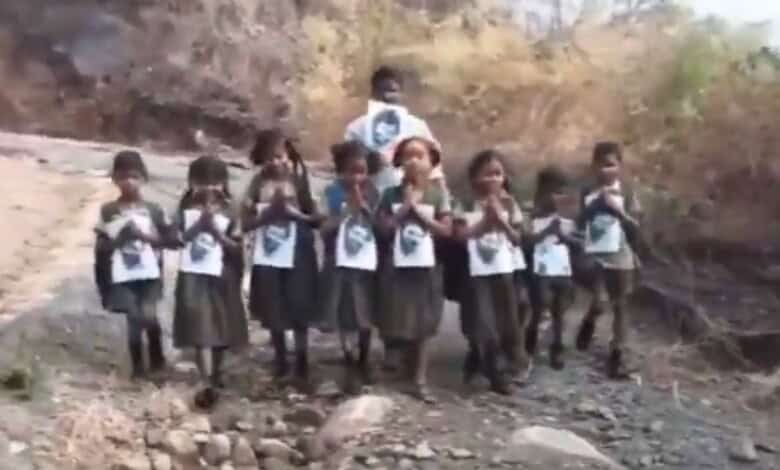 The image shows tribal children holding AP Deputy CM Pawan Kalyan's photo and requesting him to lay a road so that they could go to school in Srungavarapukota mandal of Vizianagaram district in Andhra Pradesh.