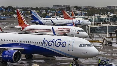 Air India, IndiGo, SpiceJet aircraft parked at airport with terminal in background.