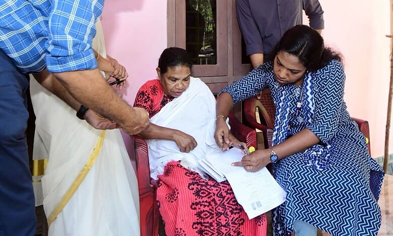 Officials reviewing electoral documents with voters in Kerala for final voter list update.