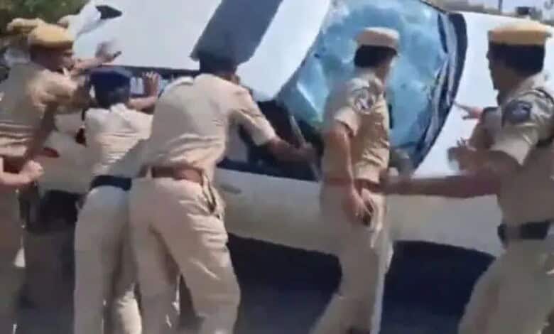 Police officers attempt to control a chaotic scene involving a vehicle during land dispute tensions in Ka.