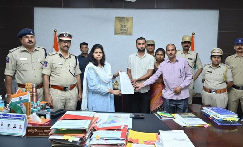 G Soumya with police officers during official document exchange at a formal event.