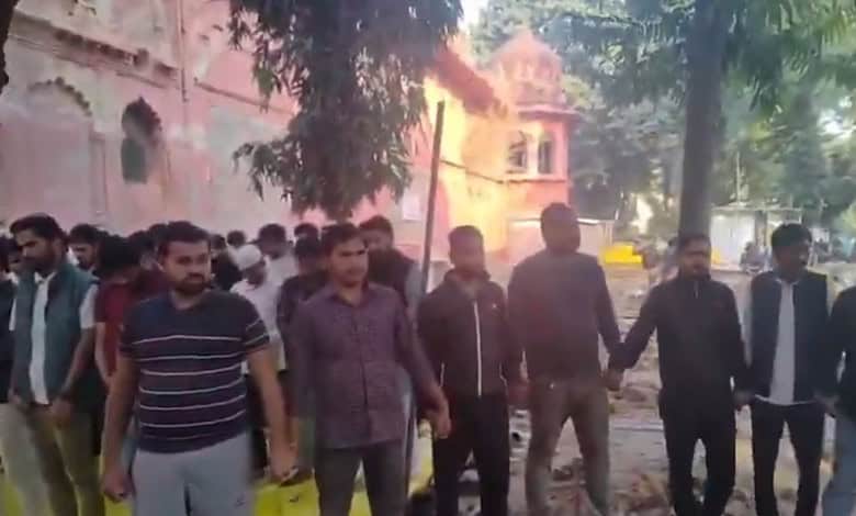 Hindu students holding hands in a human chain during Namaz prayer at Lucknow University, promoting unity.