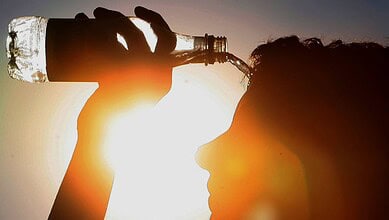 Hydrated person drinking water during Telangana summer heatwave.